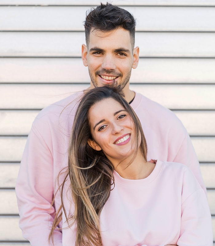 young smiling man hugging attractive happy woman